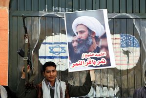 Houthi Holds Gun, al-Nimr Sign in front of US & Israeli Flags (Photo Credit- EPA)